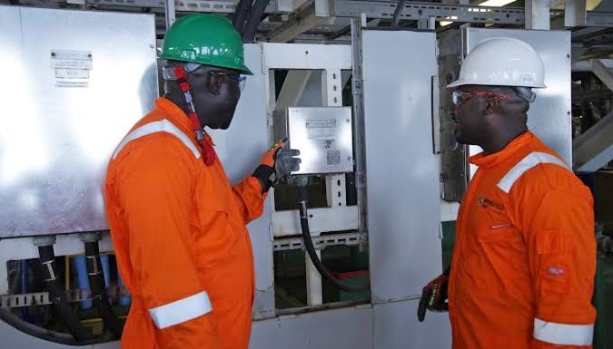 Zomik Resources field engineers inspecting industrial control panel